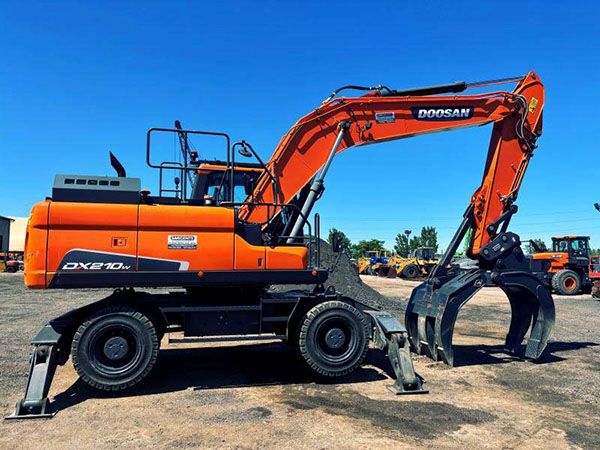 orange material handler with clow attachment